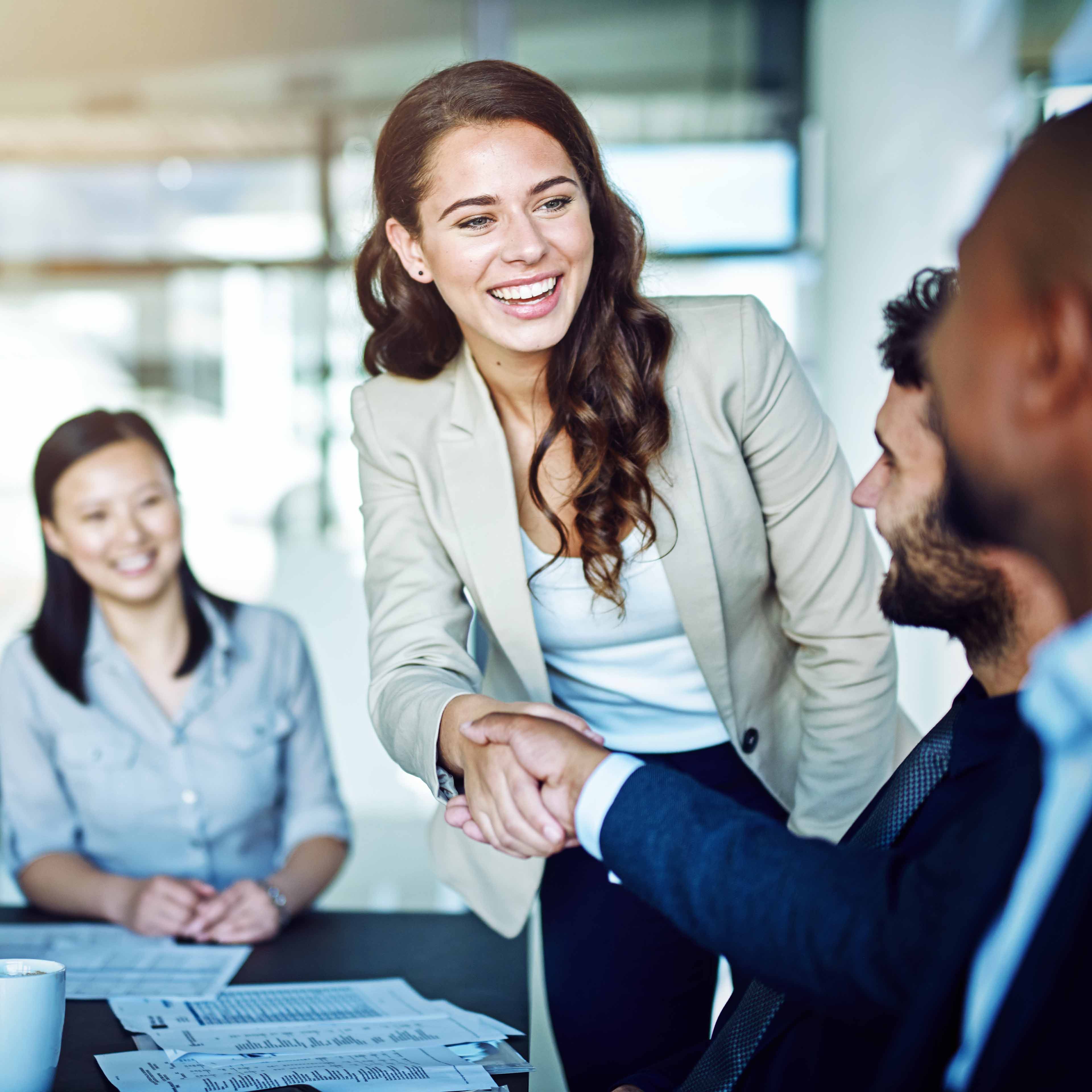 Elekta colleagues sat around a table shaking hands